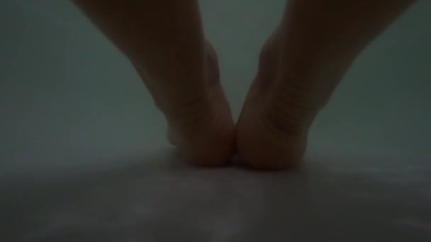 Female feet in a full bath of soapy water, a girl in the bathroom washes herself — Stock Video