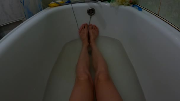 Pés femininos em um banho cheio de água ensaboada, uma menina no banheiro lava-se — Vídeo de Stock