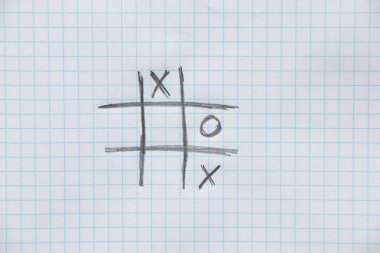 tic-tac-toe oyunu, arka plan olarak bir kafesteki bir not defterinin üzerine bir kalemle çizilir.,
