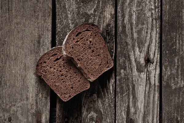 Stuk Zwart Brood Een Oud Houten Bord — Stockfoto