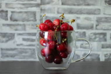 Dolu bir bardak kiraz, masada tatlı kirazlar.