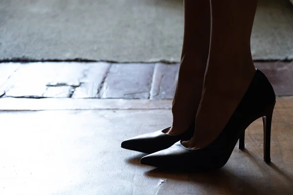 在黑暗中穿着黑高跟鞋站在地板上的女孩 穿着鞋子站在地板上的女孩 — 图库照片