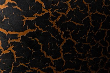 brown paint with cracked effect as background close-up, brown paint