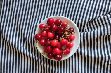ripe red cherries on a striped background, fruit background, fruits