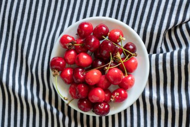 ripe red cherries on a striped background, fruit background, fruits