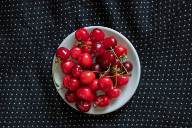 ripe red cherries on a black background, fruit background, fruits