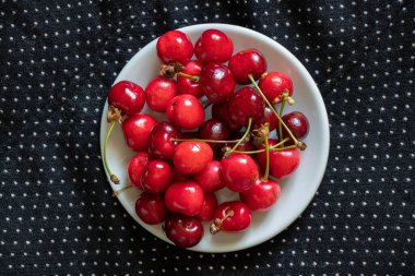 ripe red cherries on a black background, fruit background, fruits
