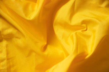 İpek sarısı buruşuk kumaş arka plan olarak yakın plan, sarı arkaplan