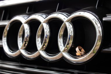 Ukrayna Dnipro 05.06.2021 - Audi arabasındaki logonun halkalarında iki altın yüzük var, arabaya yüzük dökülüyor.
