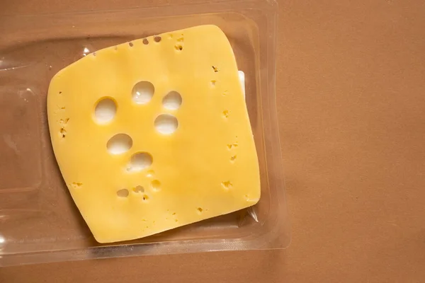 노란색 치즈를 종이에 치즈를 포장지에 먹는다 — 스톡 사진