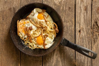 Mutfaktaki masada tavada mantarlı omlet, sahanda yumurta.