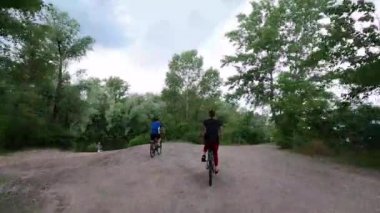 İnsanlar parkta bisiklet sürüyorlar ormanda yol boyunca bisiklet, bisiklet.