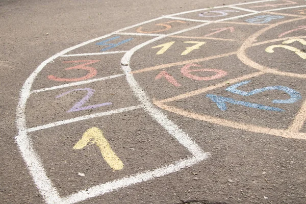 children\'s game with numbers is drawn on the asphalt in the courtyard next to a house in Ukraine, children\'s game on the road