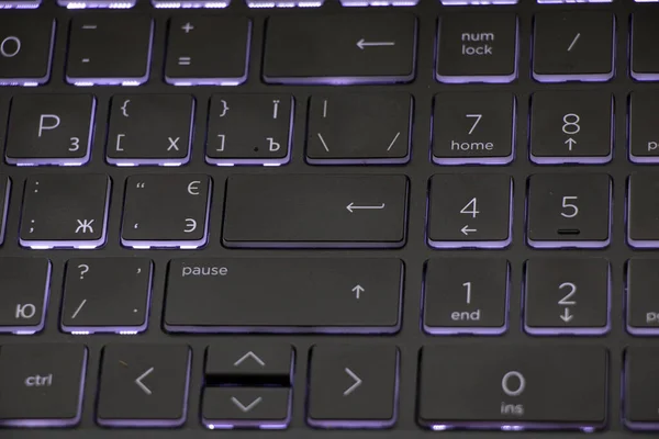 black backlit gaming laptop keyboard as background, macro oto keyboard