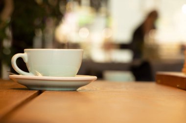 Kafedeki ahşap bir masanın üzerinde kahve, sabah kahvesi.