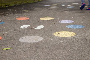 Parktaki asfaltta renkli kupalar, atlamak için asfaltta çocuklar, oynamak için çocuklar.