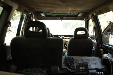 Eski bozuk araba güneşte duruyor, araba hurdalıkta.