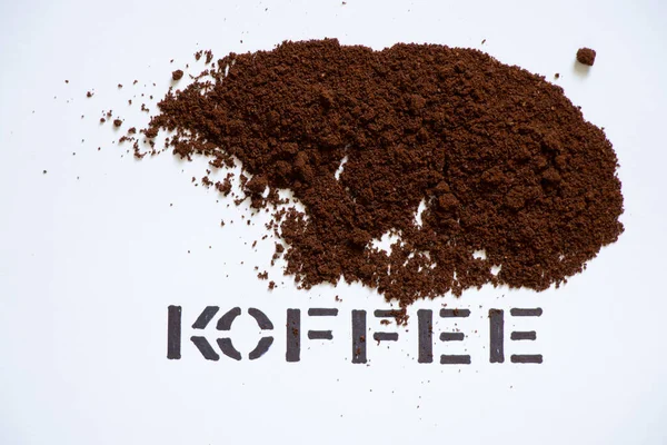 ground roasted coffee on white background and next to text coffee, coffee background, text coffee