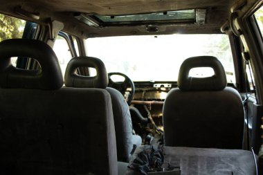 Eski bozuk araba güneşte duruyor, araba hurdalıkta.