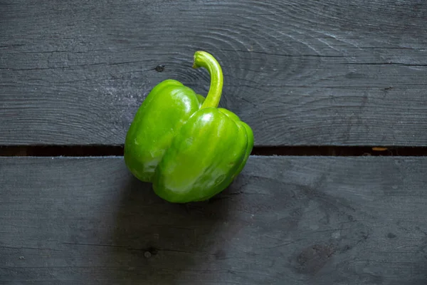 Green Raw Whole Bell Pepper Lies Black Wooden Table Green — Stock Photo, Image