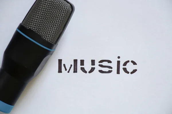 black microphone and the word music in block letters on a white background, musical microphone, music