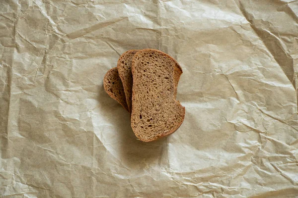 Een Stuk Zwart Brood Ligt Bruin Papier Brood — Stockfoto