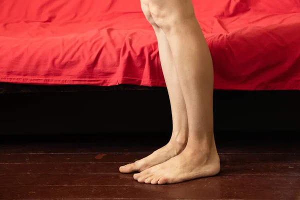 Gambe Femminili Vicino Divano Rosso Sul Vecchio Pavimento Legno Della — Foto Stock