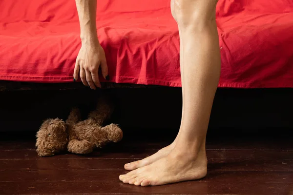 Füße Neben Dem Roten Bett Auf Dem Hölzernen Alten Fußboden — Stockfoto