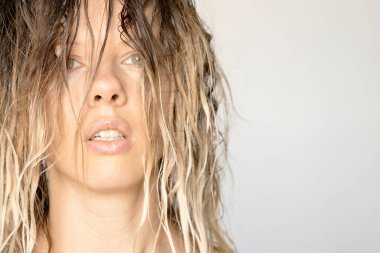 Beyaz bir arka planda genç bir kızın portresi Islak uzun saçlı, kız yüzü, manken kafası