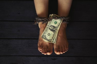 Genç bir kızın eski bir ipiyle bacağını bağlamak ve Amerikan dolarlarını kara zemine yatırmak, insan ticareti, kölelik fidyesi, vasiyet yok.