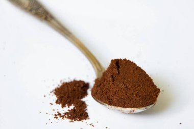 Beyaz arka planda bir kaşık dolusu kahve. Yakın plan.