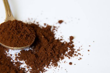 Beyaz arka planda bir kaşık dolusu kahve. Yakın plan.