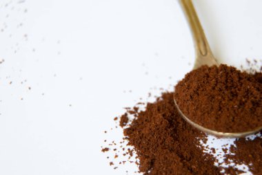 Beyaz arka planda bir kaşık dolusu kahve. Yakın plan.