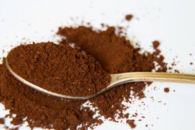 Beyaz arka planda bir kaşık dolusu kahve. Yakın plan.