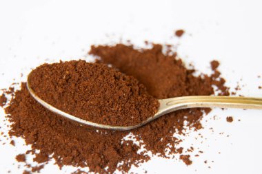 Beyaz arka planda bir kaşık dolusu kahve. Yakın plan.