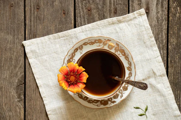 Uma Xícara Café Com Uma Flor Vermelha Maçanetas Fundo Madeira — Fotografia de Stock