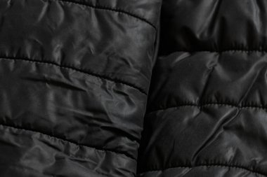 Arka plan olarak siyah yastıklı kadın ceketi, yumuşak siyah kumaşın arka plan