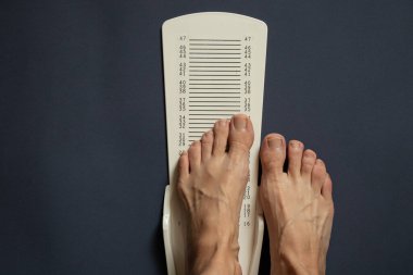 İzole bir arkaplanda bacak uzunluğunu ölçmek için kronometre, plastik bacak uzunluğu metre