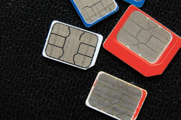 micro sim cards for the phone lie on a black background, macro photo