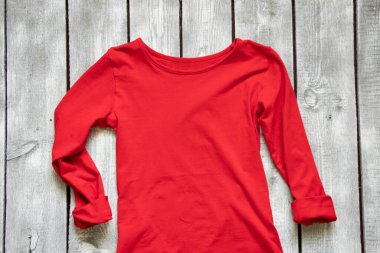 Kırmızı ceket beyaz tahta bir masanın üzerinde, kırmızı tişört.