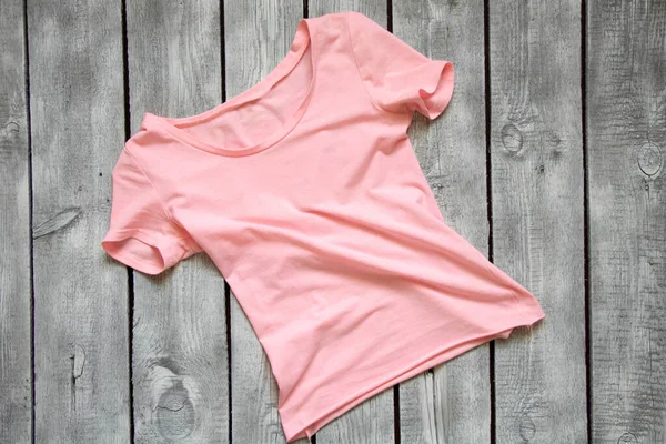 Rosa Kvinnors Shirt Ligger Ett Vitt Träbord Shirt Trä Bakgrund — Stockfoto