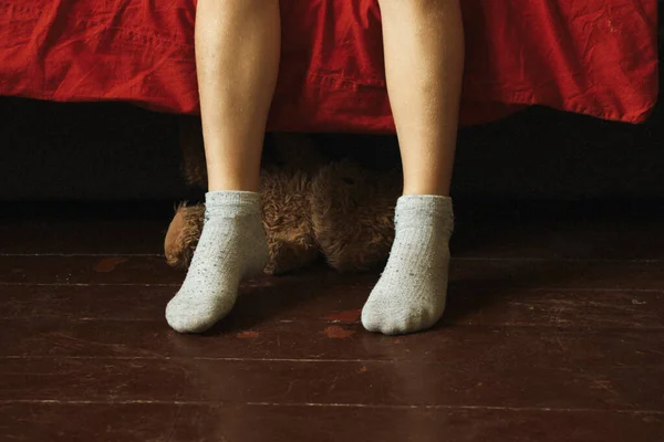 Παιδί Κάθεται Στον Καναπέ Πόδια Στο Πάτωμα Πόδια Στο Ξύλινο — Φωτογραφία Αρχείου