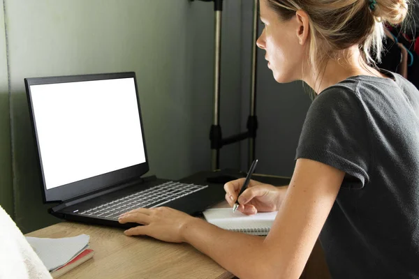 소녀가 책상에 앉아서 집안에 스크린 노트북을 집에서 자립심을 기르고 스크린 — 스톡 사진