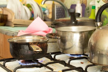 Kirli bir tencere evdeki mutfakta kirli bir gaz sobasının üzerinde duruyor, ocakta çorba pişiriyor, gaz sobası, mutfak...