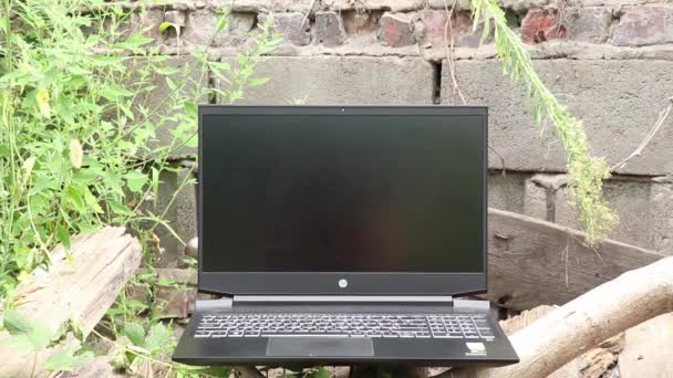 Ukraine Dnipro 26.08.2021 HP Pavilion 15 Gaming-Laptop auf einem Holztisch in einem Park in der Sonne auf einem grün verschwommenen Hintergrund — Stockvideo