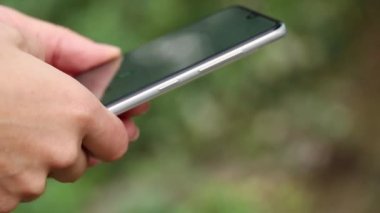 Kadın eli, sokakta telefonda daktilo çekiyor. Yakın plan, telefonla konuşuyor, arama yapıyor, mesaj yazıyor.