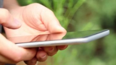 Kadın eli, sokakta telefonda daktilo çekiyor. Yakın plan, telefonla konuşuyor, arama yapıyor, mesaj yazıyor.