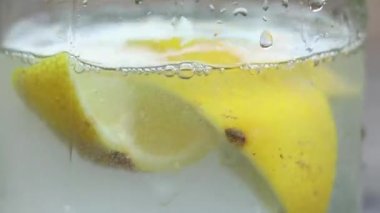 limon köpüklü suda bardakta güneş altında bir masada, su limonlu, iç