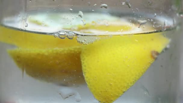 柠檬在晶莹的水里在阳光下的桌子上 水在柠檬里 — 图库视频影像
