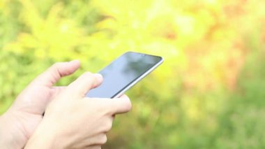 Telefon, sokaktaki bir kızın elinde. Güneşte, telefonla iletişim, telefon caddenin elinde.